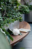 Built-in curving wooden bench seat around modern metal planters
