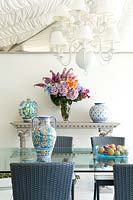 Glass table and rattan furniture with ceramics and vase