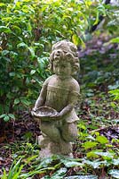 Olivia, statue of girl holding a bowl in garden. 