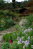 Stone steps through terraced garden to summerhouse on middle terrace. 