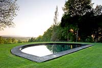 Reflection in contemporary water feature on hillside garden