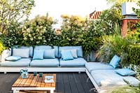 Outdoor room with loungers and plant screens of Cotinus coggygria andother plants