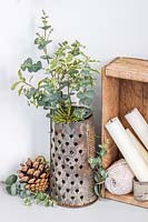 Cut foliage in old metal grater and wooden box with string and candles