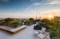 Sunset viewed from Roof Terrace to London skyline at sunset with paved seating area