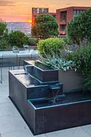 Bronze water feature on roof terrace with view to London skyline