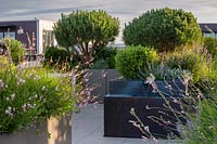 Bronze water feature on London roof terrace with container grown plants