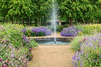 The Perennial Meadow with fountain at Scampston Hall Walled Garden, North Yorkshire, UK.
