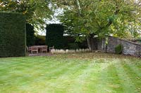 Secluded seating area beside lawn. Radcot House, Oxfordshire, UK