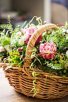 Floral arrangement in basket with roses, capsella busta pastoris, Hypericum and Eustoma.