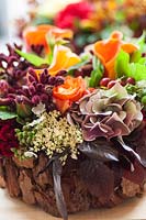 Assorted flower heads and foliage in bark container: Hydrangea, Anigozanthus and Calla
