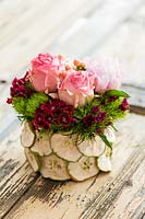 Rose and Dianthus in decorative pot made from dried fruits
