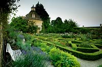 Parterre garden with Buxus - Box - edged beds, benches with Lavendula - Lavender and Alchemilla mollis, pigeon house in background 