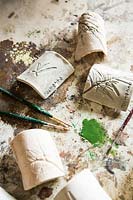 Fine paintbrushes and paint for adding colour to the impressions on ceramic plant labels