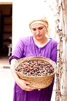 Woman holding a basket of harvested Argan nuts