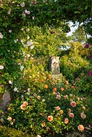 View through roses to carving on plinth 