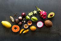 Selection of tropical fruits, some whole others cut open: Mango, Coconut, Papaya, Avocado, Pitaya, Mangosteen, Star Fruit, Passion Fruit