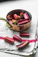 Rheum rhabarbarum 'Vierlander Blut' - Rhubarb stems cut up in saucepan 