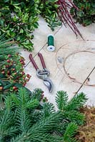 Tools and materials to make a red themed winter wreath
