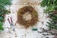 Wreath form covered with moss on workbench