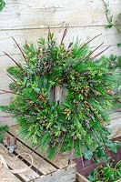 Finished wreath on workbench made with winter foliage and cuttings