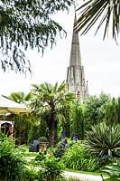 Roof garden, view of tropical beds with palms and conifers, to church steeple beyond
