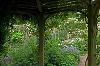 View from inside wooden gazebo to cottage garden border