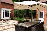 Patio with dining furniture and parasol
