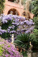 Mediterranean garden with flowering Wisteria sinensis. Villa Pergola. Alassio, Italy.