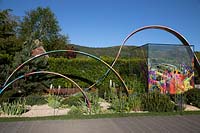 Glass cube structure and painted hoops in the What If In Support of Rees Foundation Garden 