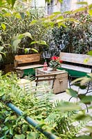 Wooden benches and trunk-table in courtyard garden.