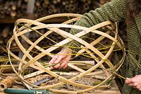 Hand weaving strips of Bamboo to create a lampshade