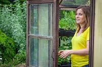 Opening a greenhouse door for ventilation in summer
