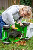 Cleaning a mower with a hand brush before storing over winter