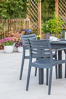 Modern table and chairs set up on context Porcelain patio