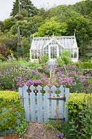 Traditional greenhouse in the kitchen garden with decorative gate