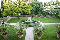 Parterre with beds of grass around a central feature and a rows of Citrus - Lemon - tree in pots 