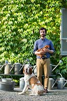 Gian Matteo Malchiodi holding a chicken and his dog Bartolomeo