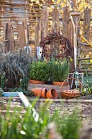 Display of garden tools, potted herbs and Onion sets