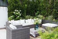 Outdoor lounge area in terrace garden, surrounded by lush planting.