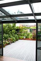 View from conservatory to terrace with planted corten containers 
