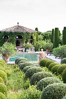 Mixed topiary beside the swimming pool with figurative sculpture. The garden focuses on perfumed evergreens