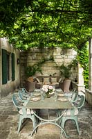 The dining table set under the wisteria pergola	