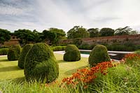 Topiary shapes on lawn next to modern swimming pool