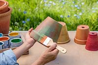 Woman painting terracotta pot green