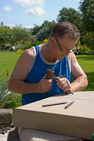 Sculptor working on a piece in his garden 