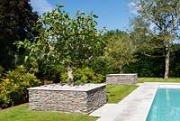 Trees planted in raised beds edged with granite walls