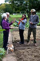 Couple enjoying talking about their allotments to another older couple with a dog on a lead