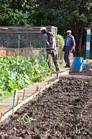People on allotments visiting fellow plot holders to have a chat