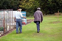 Fellow plot holders chatting whilst walking on the allotment