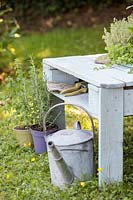 Close up detail of pallet table with central shelf for storing a pair of secateurs and gloves. 